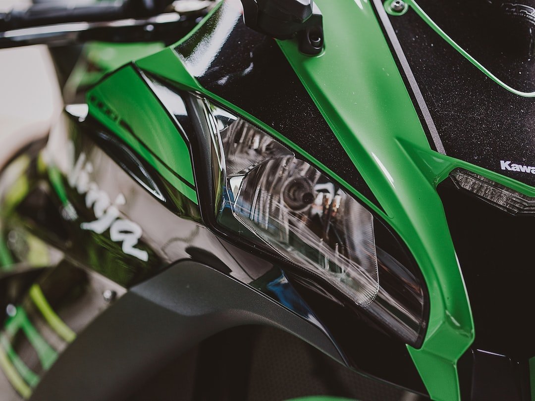 a close up of the headlight of a green motorcycle
