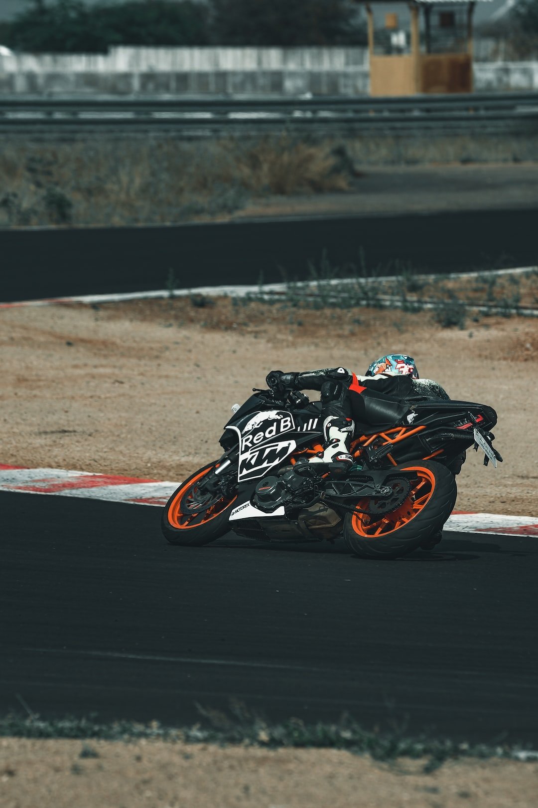 man in black and white motorcycle helmet riding on black and orange sports bike