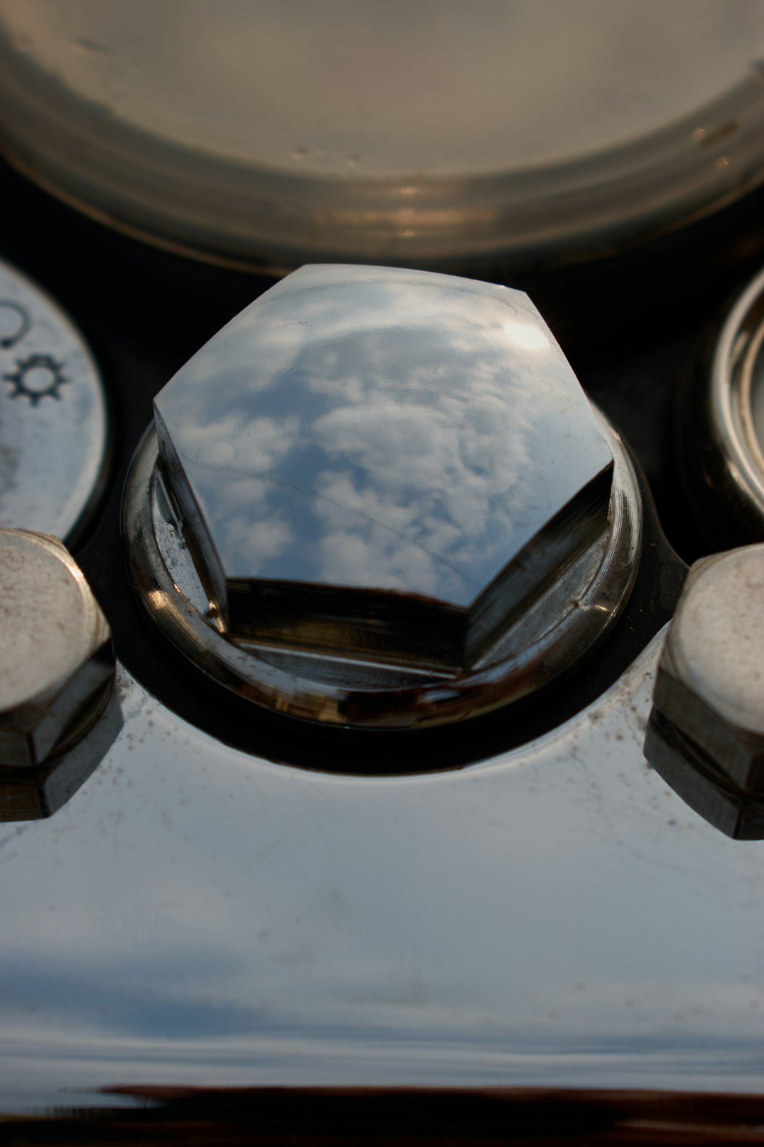 a close up of a stove top with a sky reflection in it