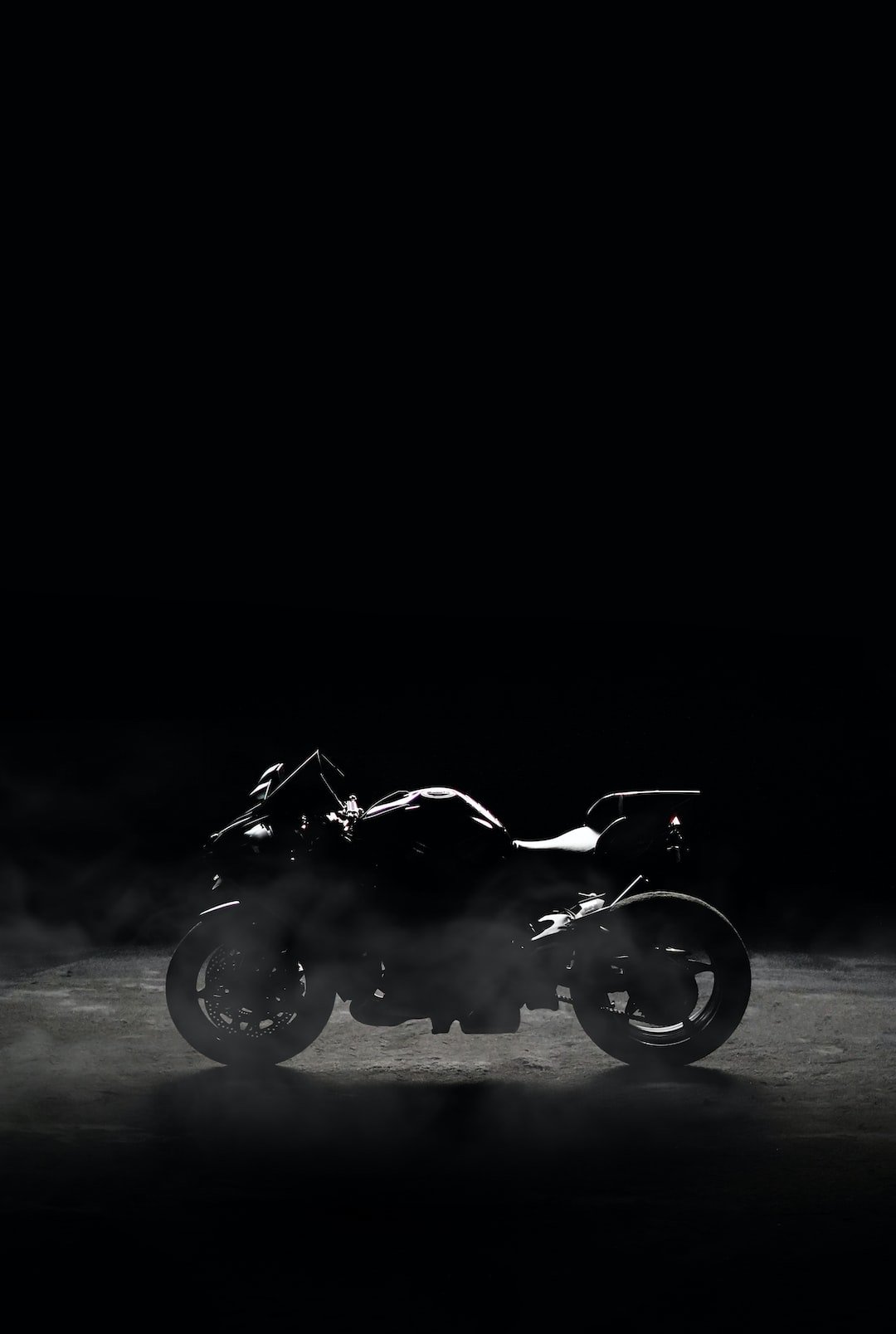 a black and white photo of a motorcycle in the dark
