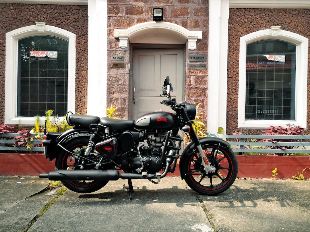 black and silver cruiser motorcycle parked beside brown concrete building during daytime
